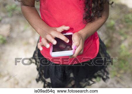Young girl in park playing hand held video game View Large Photo Image Stock Photography - Young girl in park playing hand held video game. Fotosearch