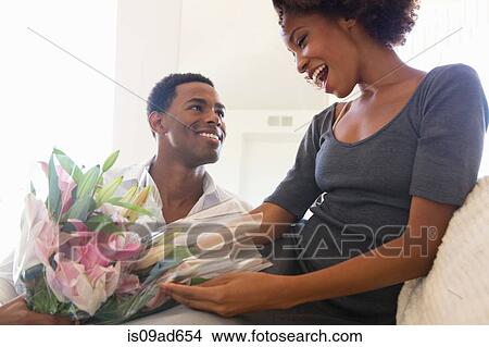 Young man giving woman bouquet View Large Photo Image Picture - Young man giving woman bouquet. Fotosearch
