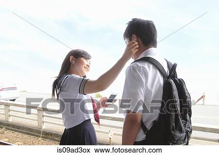 Stock Photo - Young people listening to music on smartphones. Fotosearch