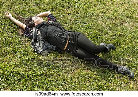 Picture - Young woman lying on grass. Fotosearch