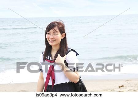 Young woman standing on beach wearing school uniform View Large Photo Image Picture - Young woman standing on beach wearing school uniform. Fotosearch