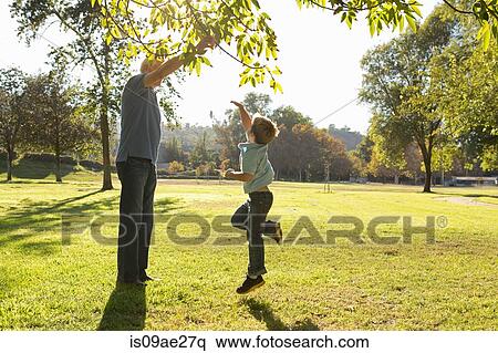 Boy jumping to reach tree branch View Large Photo Image Stock Photography - Boy jumping to reach tree branch. Fotosearch