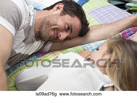 Close up of couple relaxing face to face on bed View Large Photo Image Stock Image - Close up of couple relaxing face to face on bed. Fotosearch