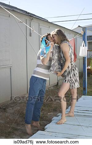 Stock Image - Couple kissing over washing line, Breezy Point, Queens, New York, USA. Fotosearch