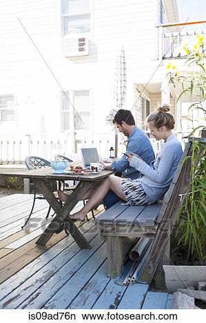 Couple on patio with laptop and mobile, Breezy Point, Queens, New York, USA View Large Photo Image Picture - Couple on patio with laptop and mobile, Breezy Point, Queens, New York, USA. Fotosearch