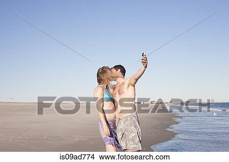 Couple taking self portrait on beach, Breezy Point, Queens, New York, USA View Large Photo Image Picture - Couple taking self portrait on beach, Breezy Point, Queens, New York, USA. Fotosearch