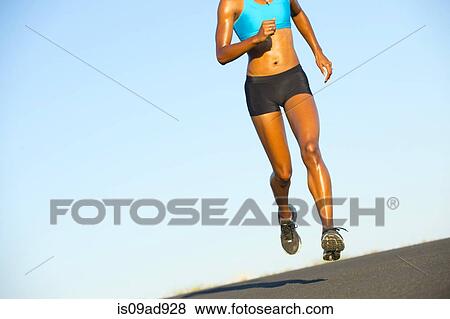 Detail of young woman running on road View Large Photo Image Stock Photo - Detail of young woman running on road. Fotosearch