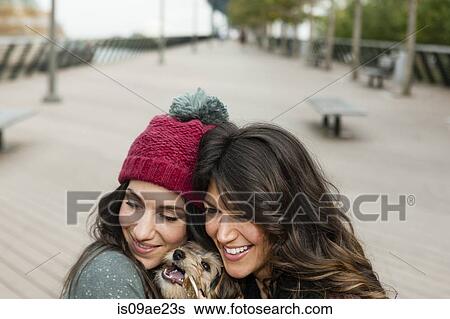 Friends holding pet dog for photograph View Large Photo Image Stock Photograph - Friends holding pet dog for photograph. Fotosearch