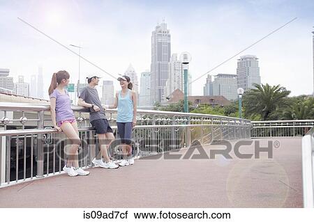 Stock Image - Friends taking a break from running in Shanghai, China. Fotosearch