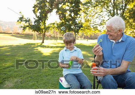 Grandfather and grandson blowing bubbles View Large Photo Image Picture - Grandfather and grandson blowing bubbles. Fotosearch