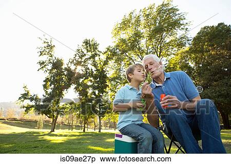Grandfather and grandson blowing bubbles View Large Photo Image Stock Photography - Grandfather and grandson blowing bubbles. Fotosearch