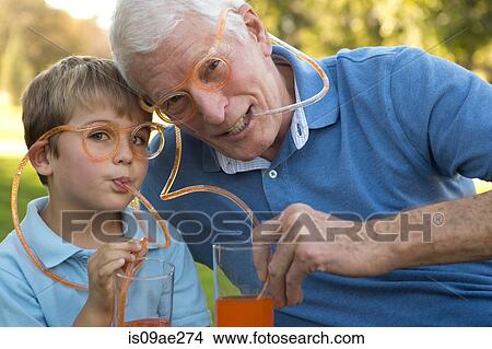 Grandfather and grandson drinking through straw eyeglasses View Large Photo Image Picture - Grandfather and grandson drinking through straw eyeglasses. Fotosearch