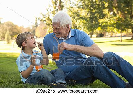 Stock Photography - Grandfather and grandson drinking through straw eyeglasses. Fotosearch