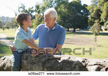 Grandfather and grandson in park, sitting on tree View Large Photo Image Stock Image - Grandfather and grandson in park, sitting on tree. Fotosearch