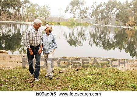 Stock Photograph - Husband and wife chatting happily by the lake. Fotosearch