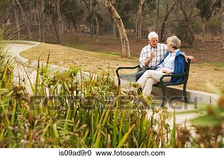 Husband and wife chatting lovingly on park bench View Large Photo Image Stock Image - Husband and wife chatting lovingly on park bench. Fotosearch