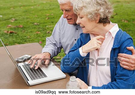 Husband and wife learning to use laptop in the park View Large Photo Image Stock Photography - Husband and wife learning to use laptop in the park. Fotosearch