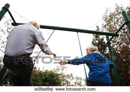 Stock Image - Husband and wife on swing. Fotosearch