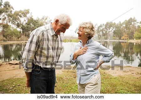 Husband and wife sharing joke by the lake View Large Photo Image Picture - Husband and wife sharing joke by the lake. Fotosearch