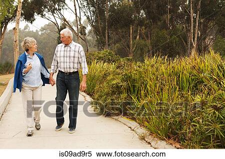 Husband and wife strolling and chatting in the park View Large Photo Image Stock Photography - Husband and wife strolling and chatting in the park. Fotosearch
