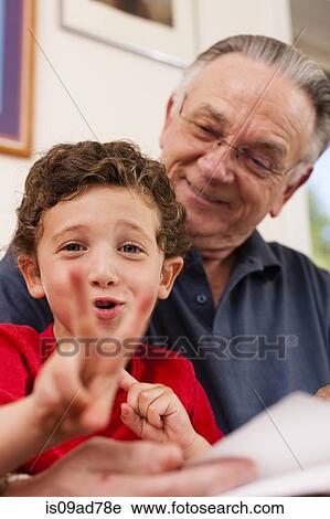 Stock Image - Portrait of young boy and grandfather playing. Fotosearch