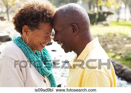 Stock Image - Senior couple face to face, smiling. Fotosearch