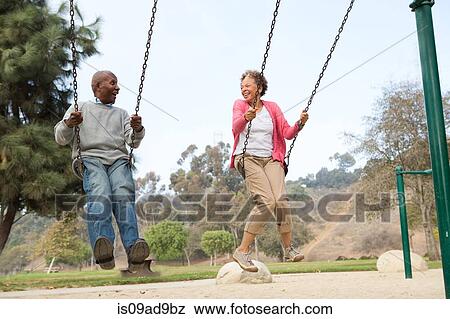 Senior couple on swings in park View Large Photo Image Stock Photo - Senior couple on swings in park. Fotosearch