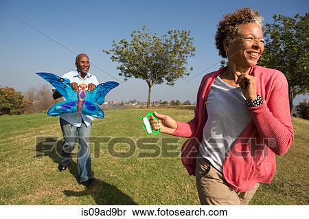 Senior couple running in park with kite View Large Photo Image Stock Photography - Senior couple running in park with kite. Fotosearch