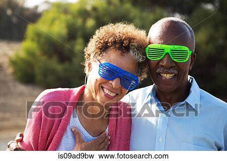 Stock Photo - Senior couple wearing blue and green plastic glasses. Fotosearch