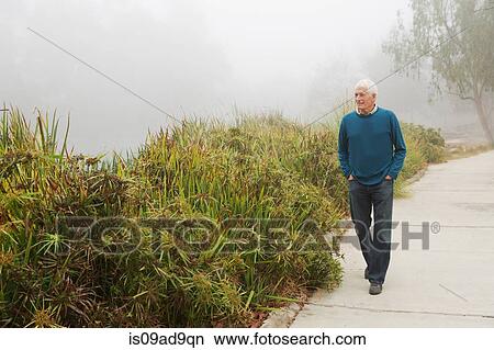 Senior man enjoying stroll in the park View Large Photo Image Picture - Senior man enjoying stroll in the park. Fotosearch