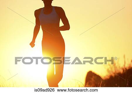 Silhouette of young woman running at sunset View Large Photo Image Stock Photograph - Silhouette of young woman running at sunset. Fotosearch