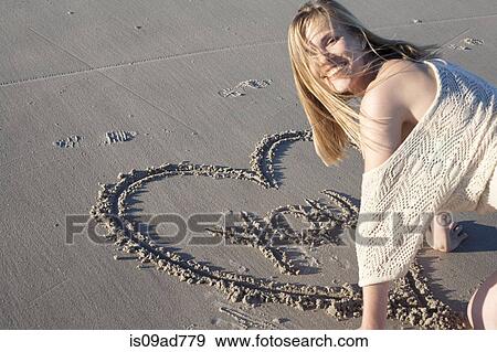 Smiling woman writing love message in sand, Breezy Point, Queens, New York, USA View Large Photo Image Stock Photo - Smiling woman writing love message in sand, Breezy Point, Queens, New York, USA. Fotosearch