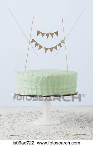 Stock Image - Still life of celebration cake decorated with flag bunting. Fotosearch