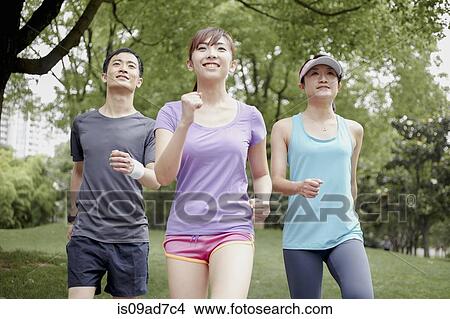 Three young people jogging in park View Large Photo Image Picture - Three young people jogging in park. Fotosearch