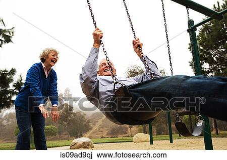 Wife pushing husband on swing View Large Photo Image Stock Image - Wife pushing husband on swing. Fotosearch