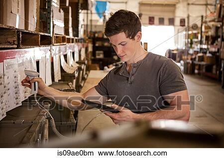 Worker in warehouse scanning barcode on cardboard box View Large Photo Image Picture - Worker in warehouse scanning barcode on cardboard box. Fotosearch