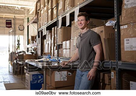 Worker standing in warehouse, leaning against shelving View Large Photo Image Stock Photo - Worker standing in warehouse, leaning against shelving. Fotosearch