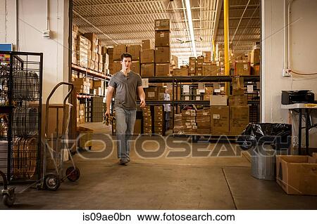 Worker walking through warehouse View Large Photo Image Picture - Worker walking through warehouse. Fotosearch