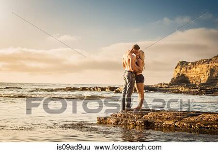 Stock Photograph - Young couple kissing on rocks, Sunset Cliffs, San Diego, California, USA. Fotosearch