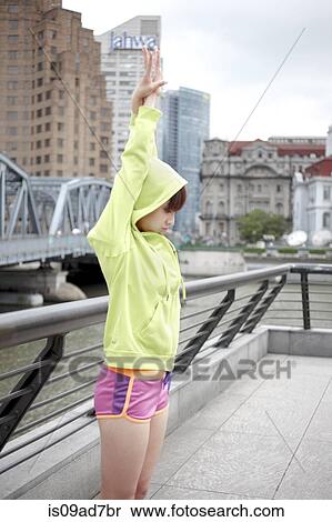 Stock Photography - Young female jogger stretching. Fotosearch
