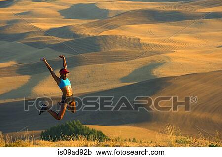 Young female runner jumping for joy in fields, Bainbridge Island, Washington State, USA View Large Photo Image Stock Image - Young female runner jumping for joy in fields, Bainbridge Island, Washington State, USA. Fotosearch