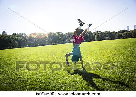 Young man doing cartwheel in park View Large Photo Image Stock Photograph - Young man doing cartwheel in park. Fotosearch