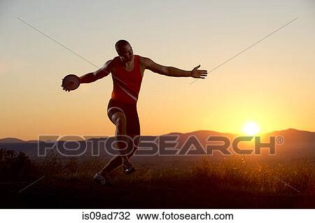 Young man preparing to throwing discus at sunset View Large Photo Image Stock Image - Young man preparing to throwing discus at sunset. Fotosearch