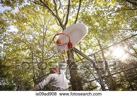 Young man scoring basketball goal View Large Photo Image Stock Photo - Young man scoring basketball goal. Fotosearch