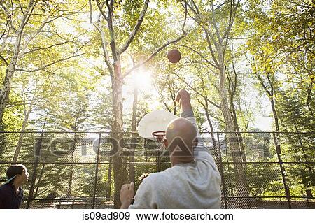 Young man throwing basketball towards goal View Large Photo Image Stock Photo - Young man throwing basketball towards goal. Fotosearch