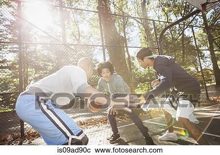 Stock Image - Young men playing basketball. Fotosearch