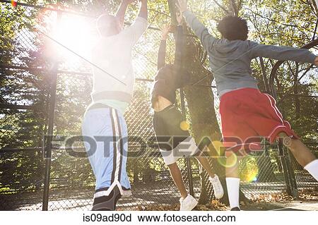 Stock Image - Young men playing basketball. Fotosearch