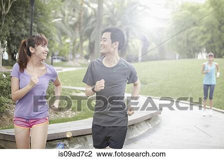 Stock Image - Young people running in park. Fotosearch