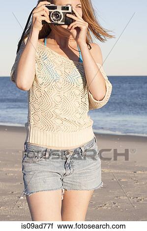 Young woman holding camera on beach, Breezy Point, Queens, New York, USA View Large Photo Image Stock Image - Young woman holding camera on beach, Breezy Point, Queens, New York, USA. Fotosearch