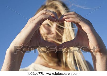 Young woman making heart sign with hands, Breezy Point, Queens, New York, USA View Large Photo Image Stock Image - Young woman making heart sign with hands, Breezy Point, Queens, New York, USA. Fotosearch